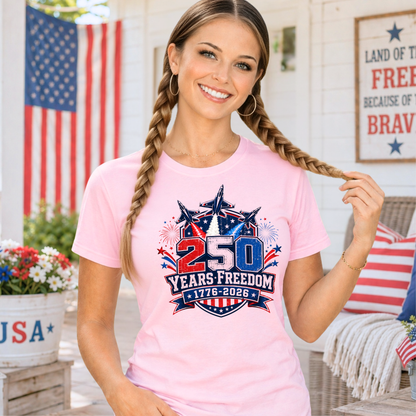 Woman wearing a pink t-shirt with a 250 Years Freedom design, standing in front of an American flag.