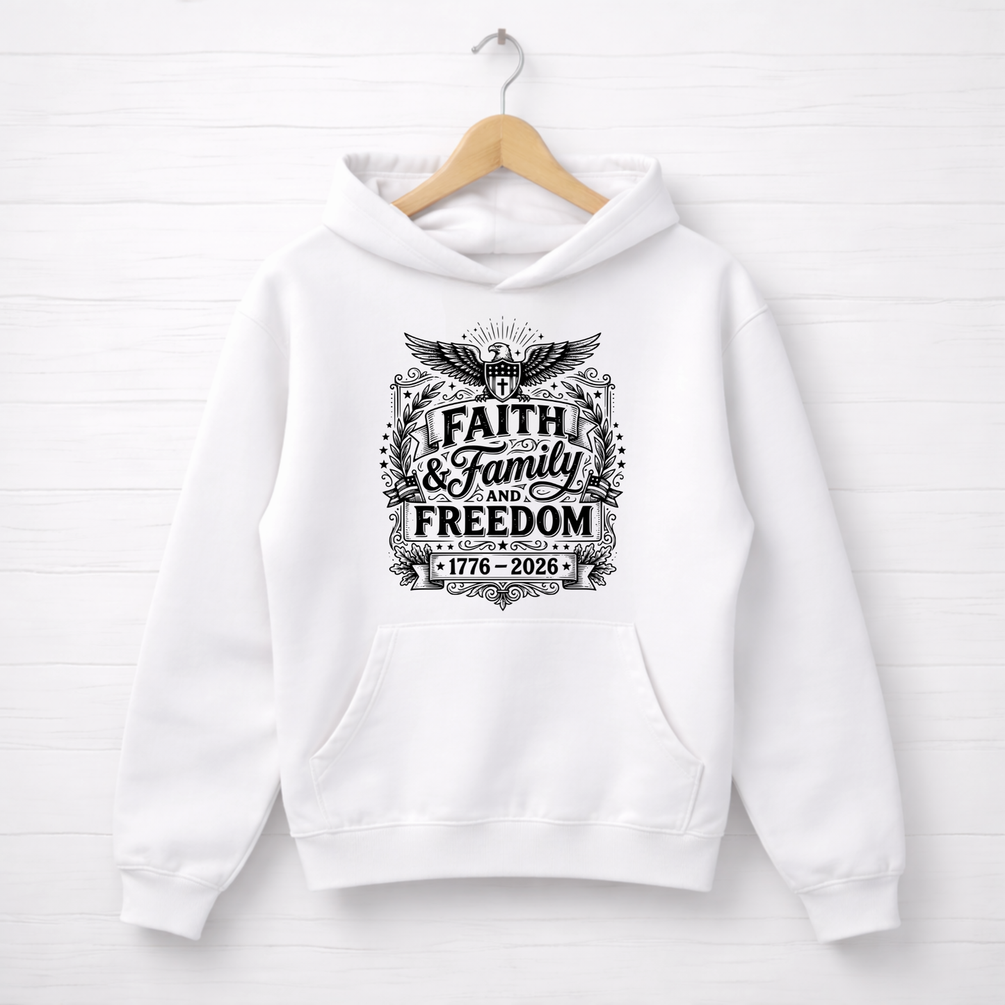 White hoodie with 'Faith & Family Freedom' text on a wooden hanger against a white background