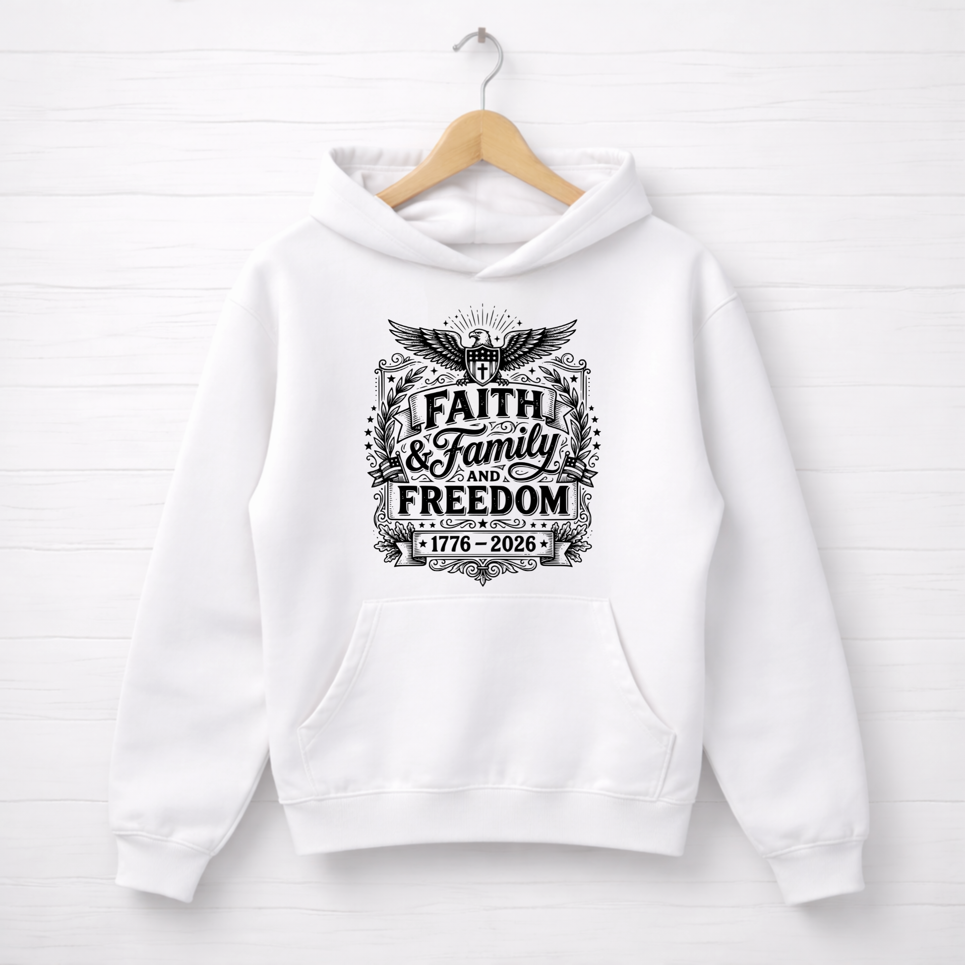 White hoodie with 'Faith & Family Freedom' text on a wooden hanger against a white background