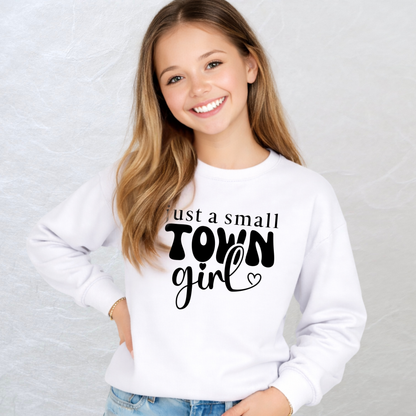 Girl wearing a white sweatshirt with 'just a small town girl' text on a light gray background
