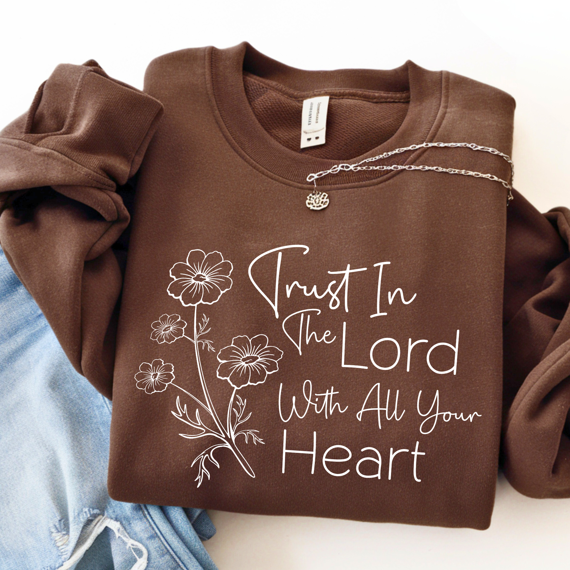 Brown sweatshirt with floral design and text on a white background