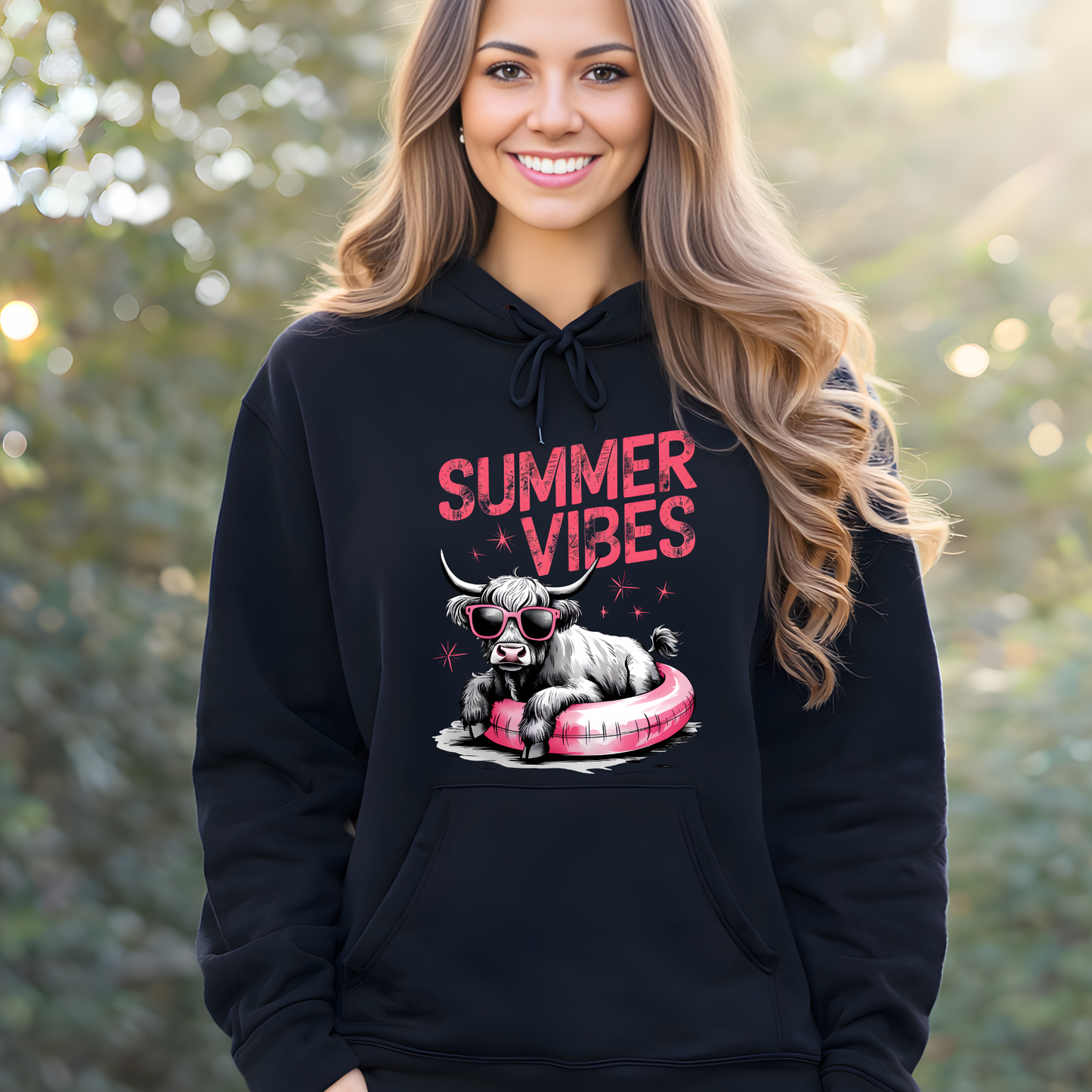 Woman wearing a black hoodie with 'Summer Vibes' graphic design outdoors.