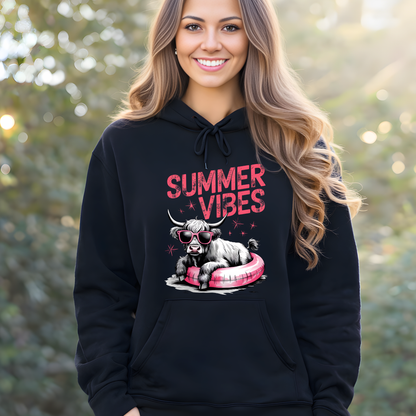 Woman wearing a black hoodie with 'Summer Vibes' graphic design outdoors.