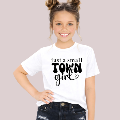 Young girl wearing a white t-shirt with 'just a small town girl' text on a plain background