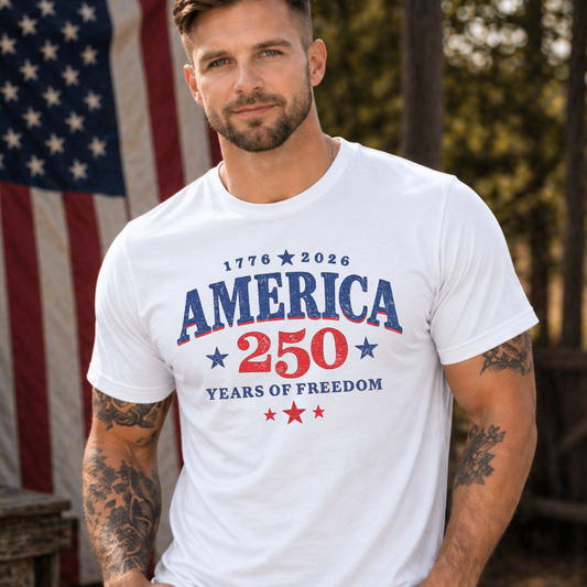 Man wearing a white t-shirt with 'America 250 Years of Freedom' design in front of an American flag.