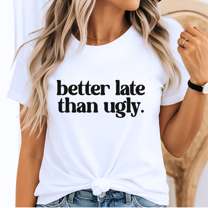White t-shirt with 'better late than ugly' text worn by a woman.