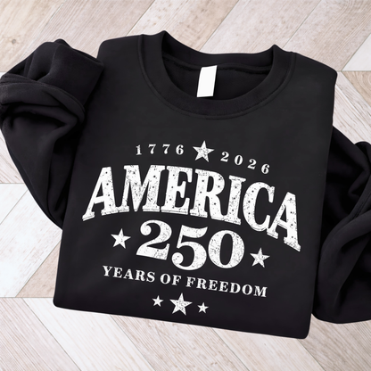 Black sweatshirt with 'America 250 Years of Freedom' text on a wooden floor.