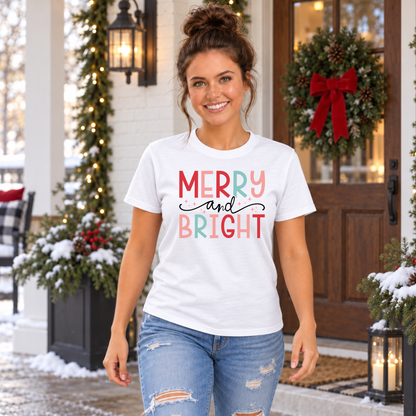 Woman wearing a white T-shirt with colorful Merry and Bright Christmas design on a snowy decorated porch