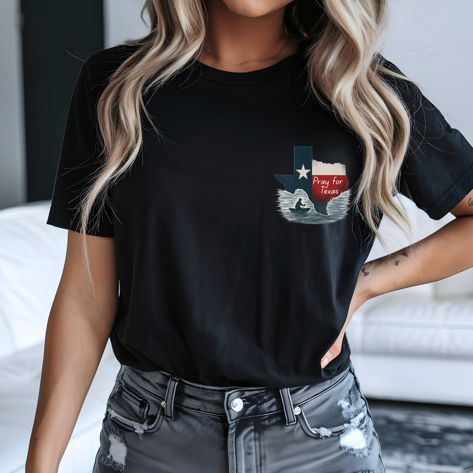 Person wearing a black t-shirt with a graphic design, standing indoors.