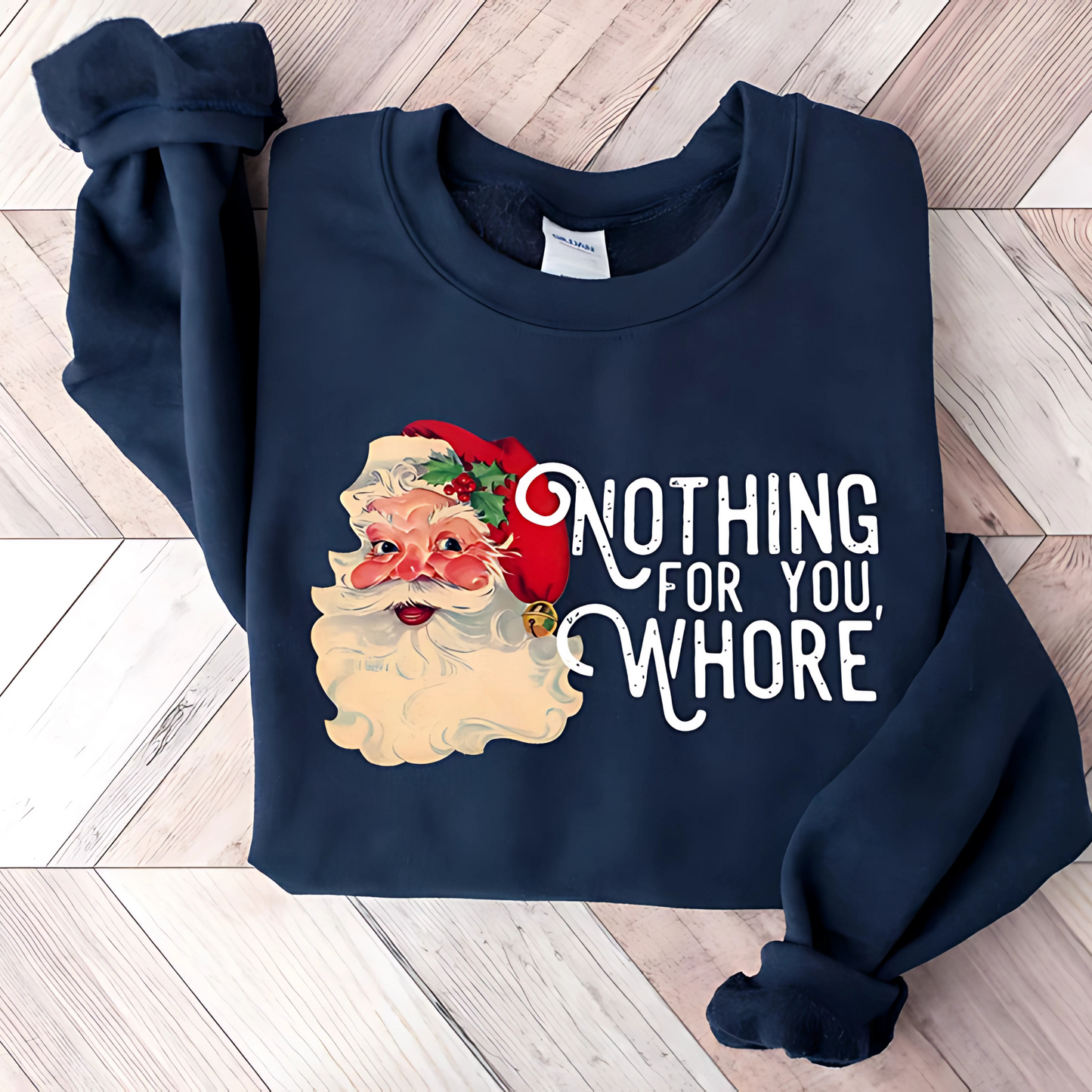 Navy Sweatshirt Flat Lay – Funny Santa "Nothing For You, Whore" quote sweatshirt on navy Gildan crewneck folded on wood floor