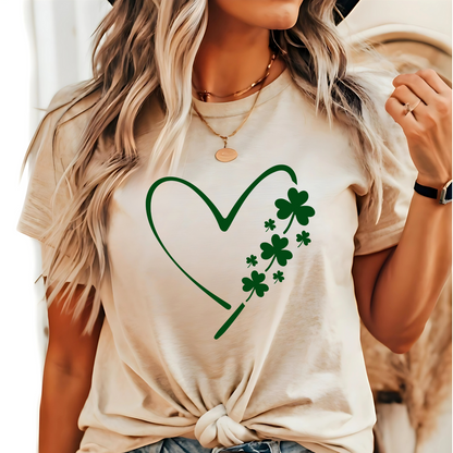 A woman wearing a tan T-shirt with a minimalist green heart and shamrock design, perfect for St. Patrick’s Day celebrations.