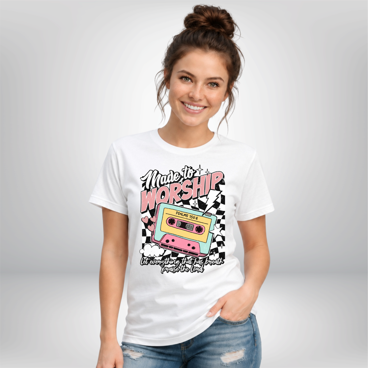 Woman wearing a white Made to Worship T-shirt with a retro cassette graphic on a studio background.