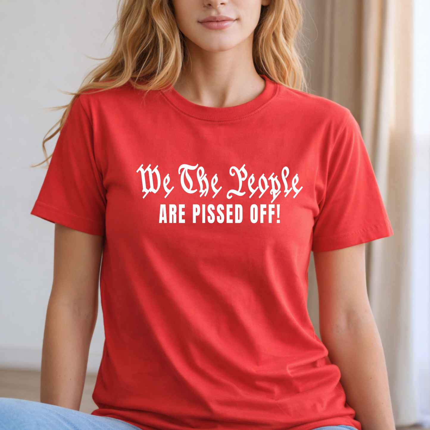 Person wearing a red t-shirt with text 'We The People ARE PISSED OFF!'