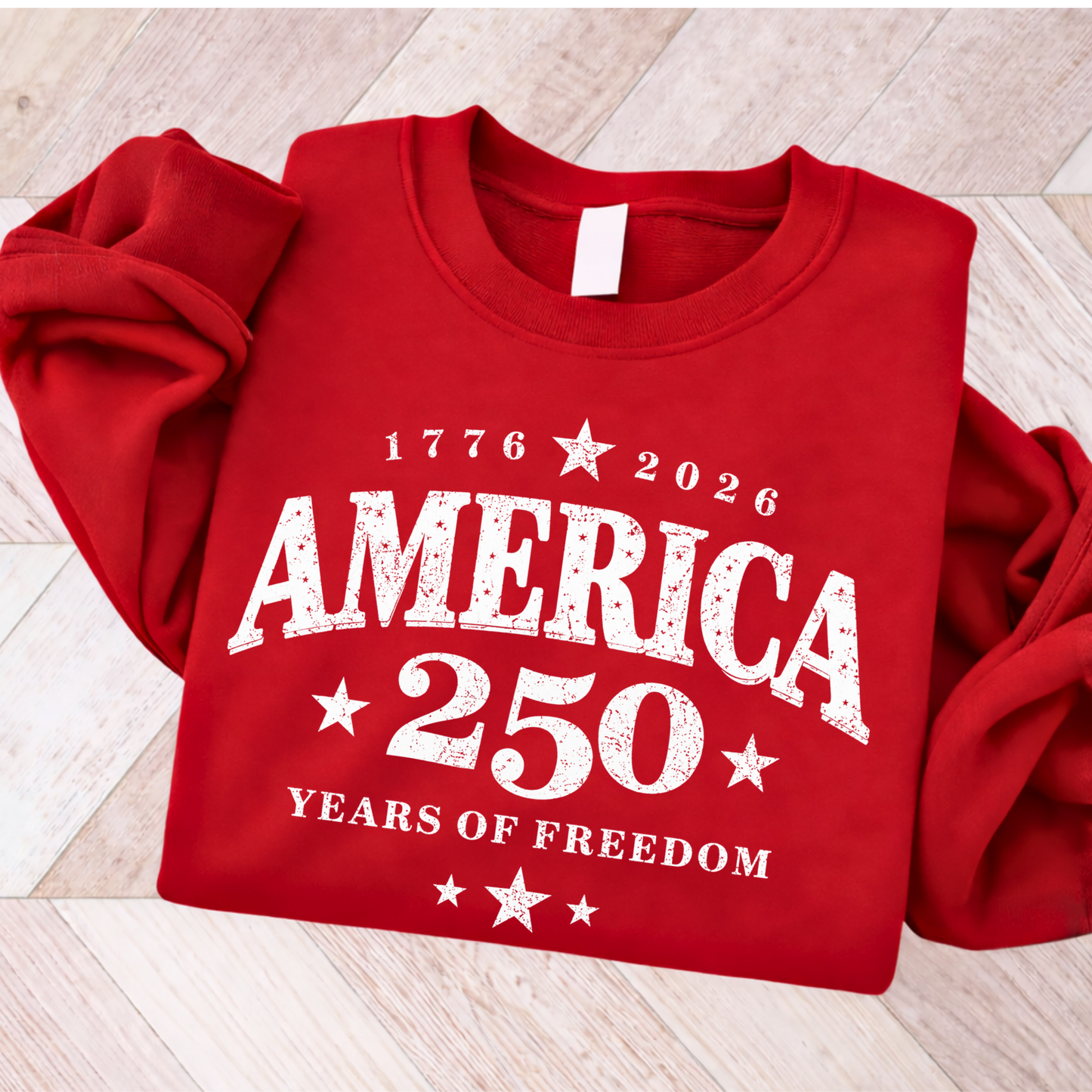 Red sweatshirt with 'America 250 Years of Freedom' text on a wooden surface