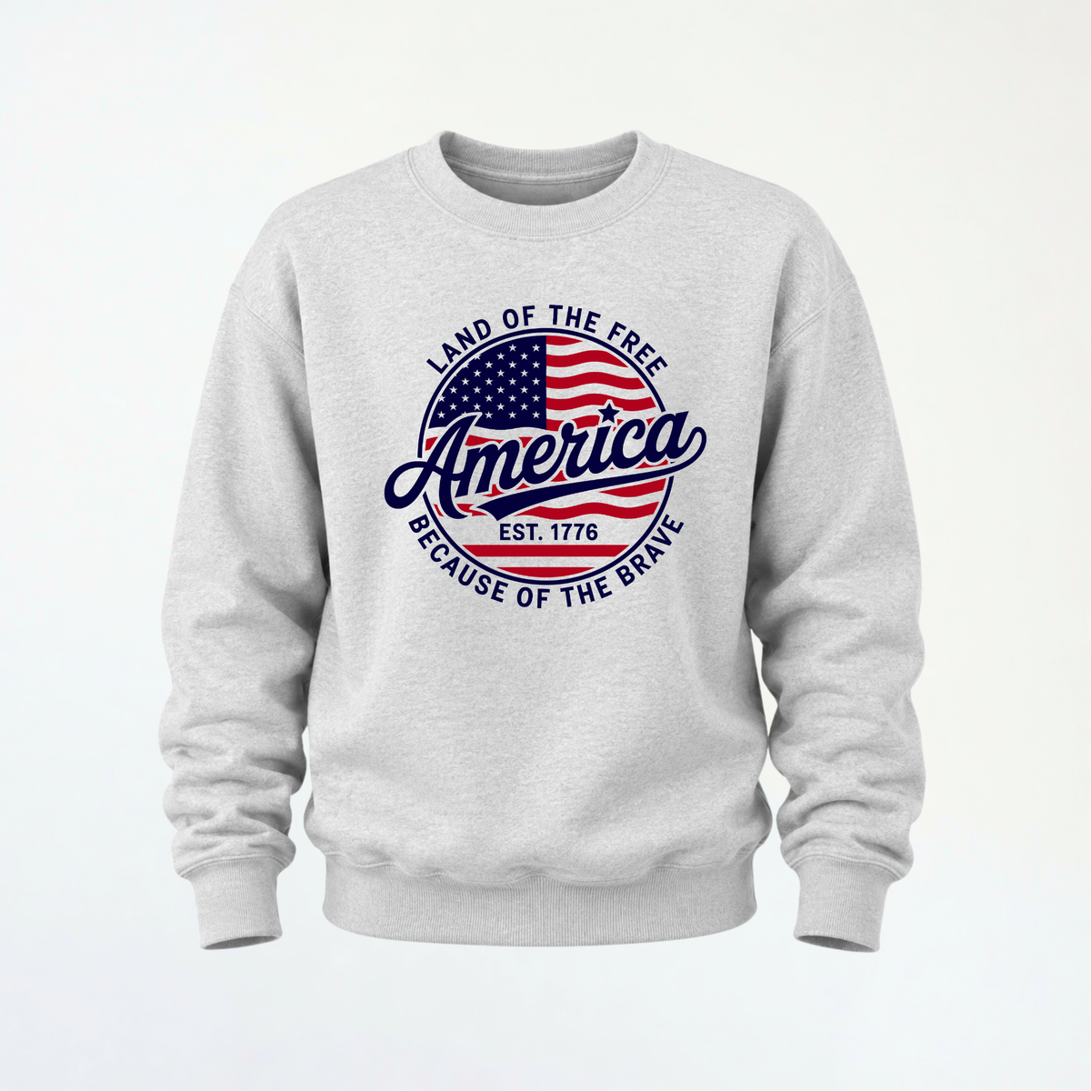 Sports gray crewneck sweatshirt flat lay with a red, white, and blue circular America graphic reading Land of the Free, Est. 1776, and Because of the Brave.