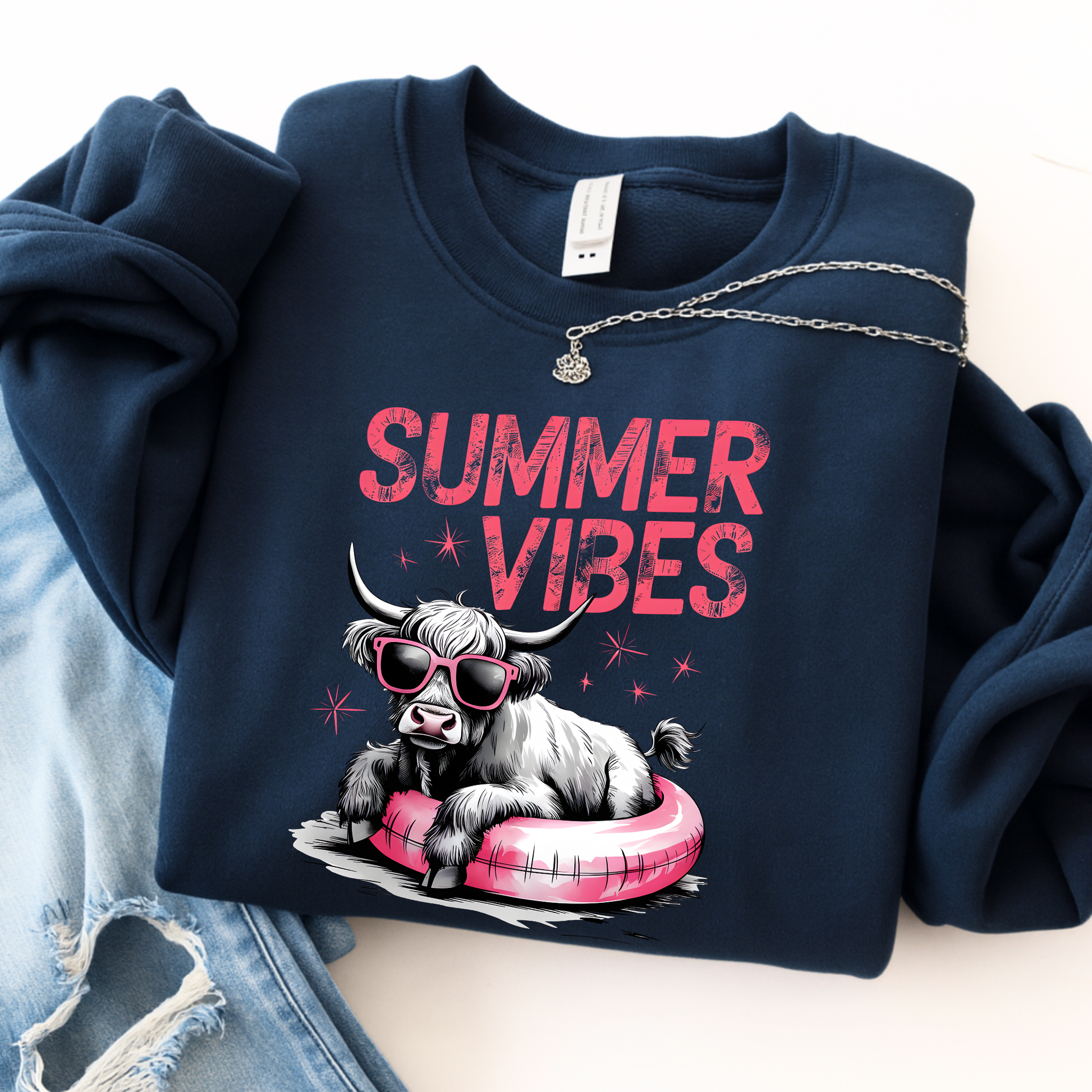 Navy blue sweatshirt with 'Summer Vibes' text and a graphic of a highland  cow on a pink inner tube.