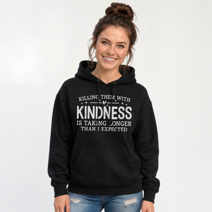 Woman wearing a black hoodie with white Killing Them With Kindness lettering against a white background.