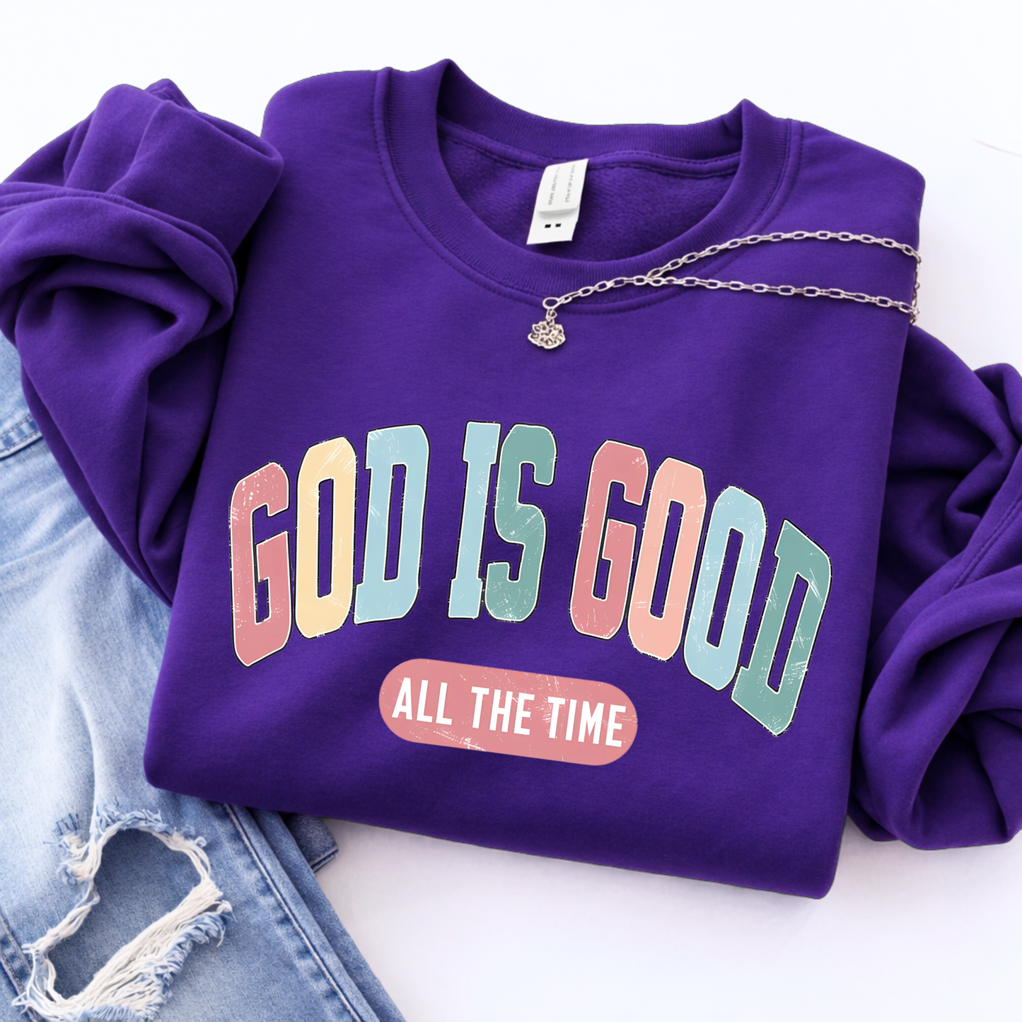 Purple sweatshirt with 'God is Good All the Time' text on a white background