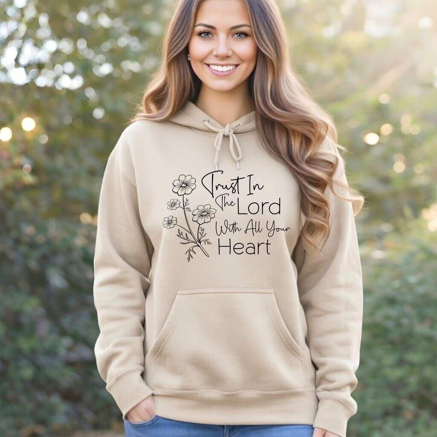 Woman wearing a beige hoodie with a motivational quote outdoors