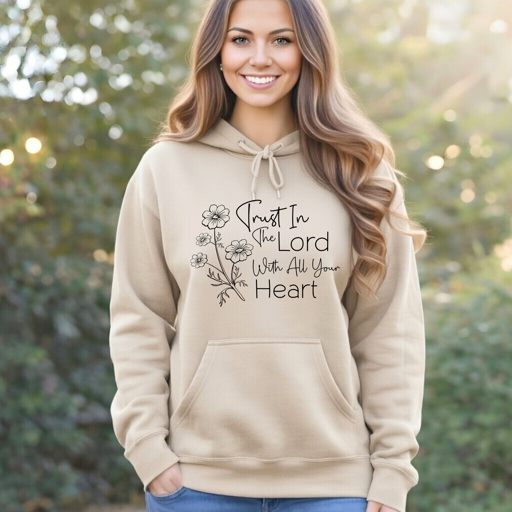 Woman wearing a beige hoodie with a motivational quote outdoors