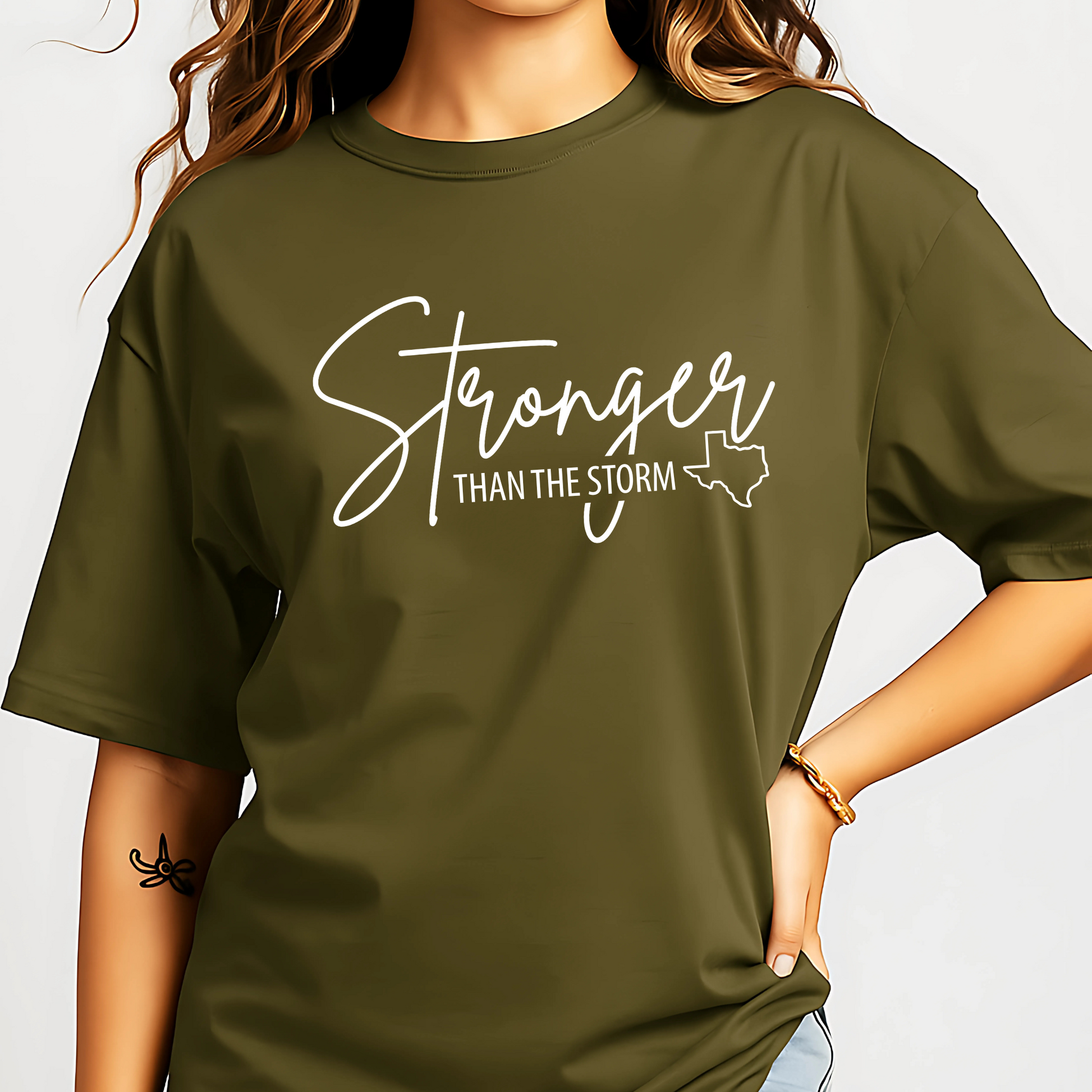 Person wearing a green t-shirt with 'Stronger Than The Storm' text design.