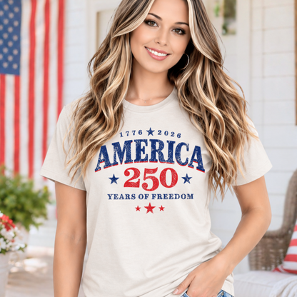 Woman wearing a 'America 250 Years of Freedom' t-shirt in an outdoor setting with American flags.