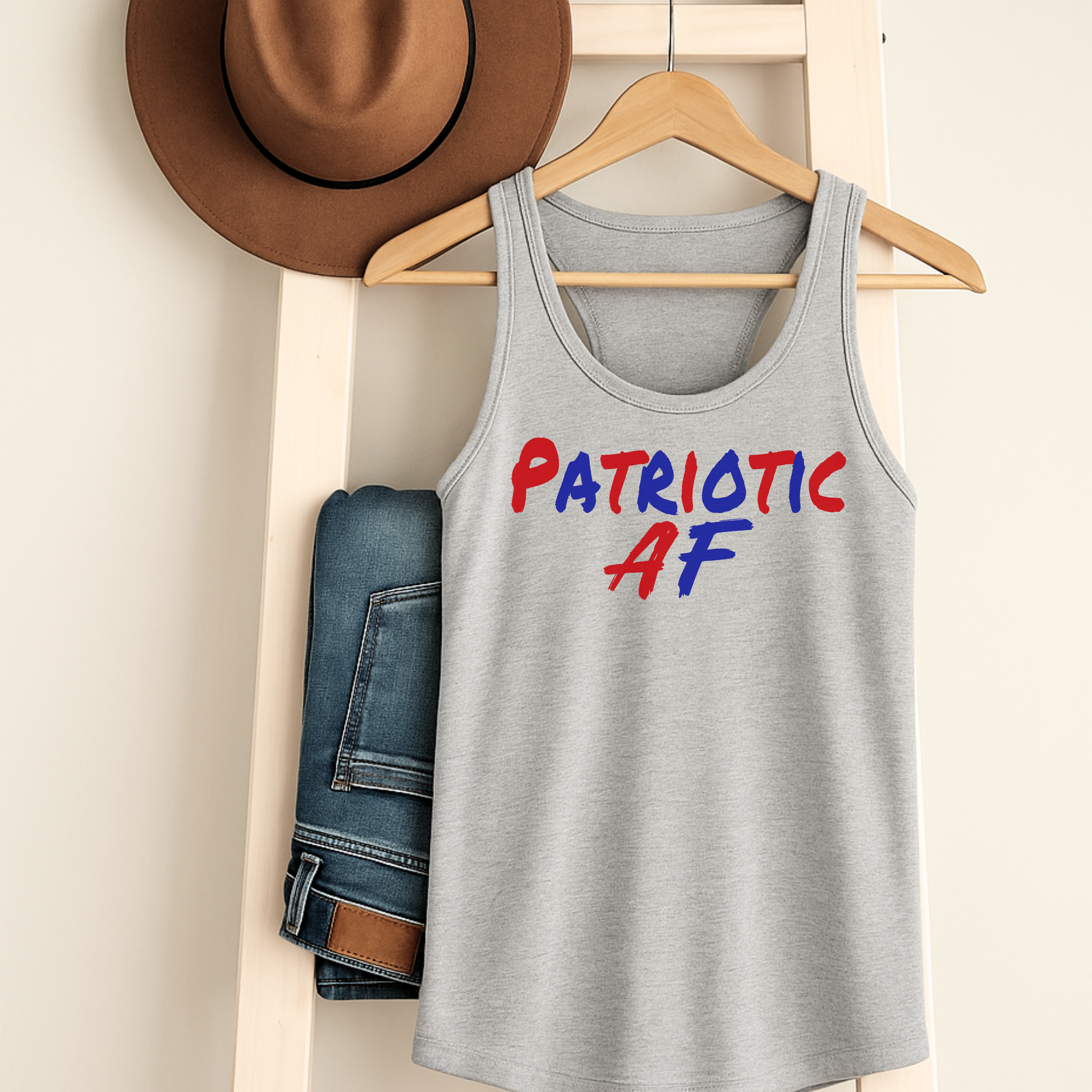 Sport gray classic tank top on hanger with jeans and hat, featuring "Patriotic AF" print.

