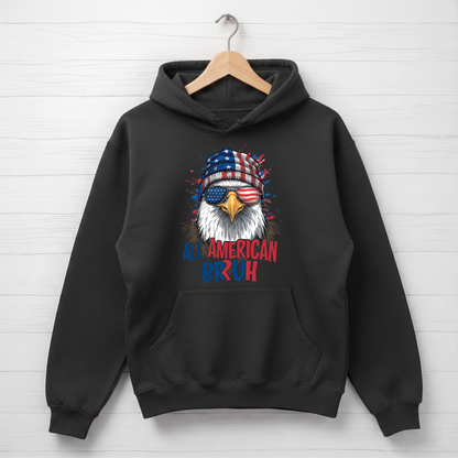 Black hoodie with an eagle design and 'All American Bruh' text on a white wooden background