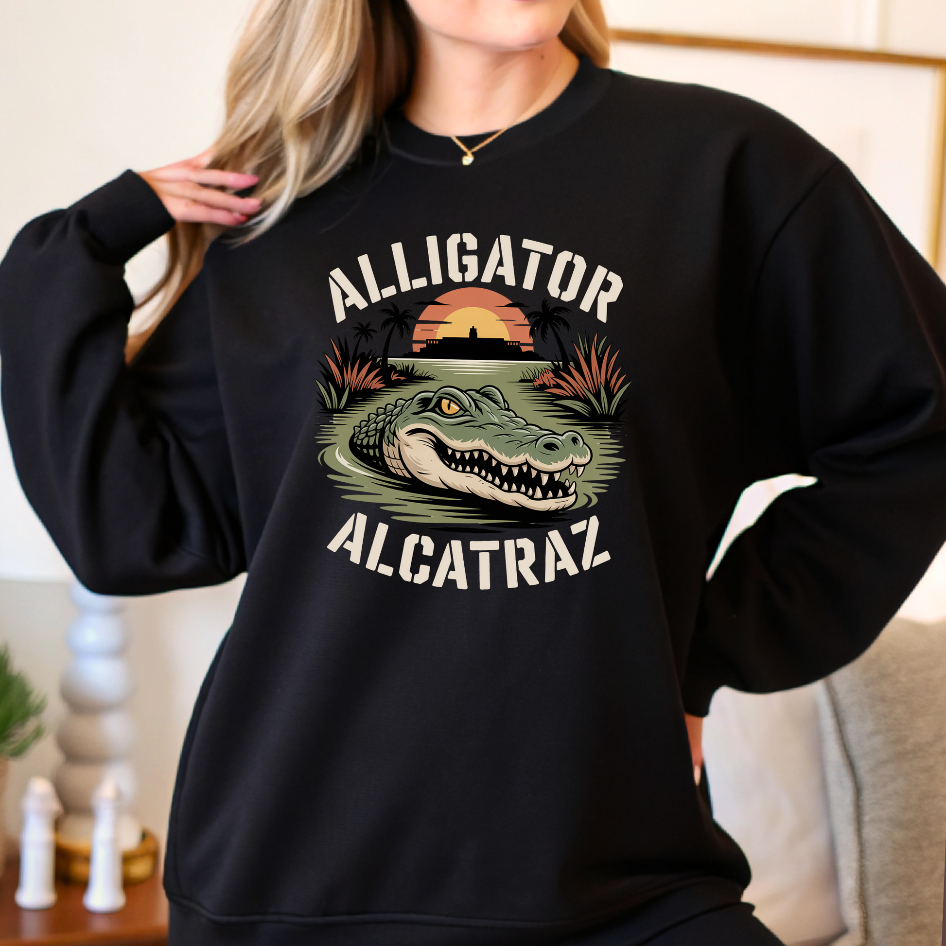 Black sweatshirt with 'Alligator Alcatraz' graphic design worn by a person.