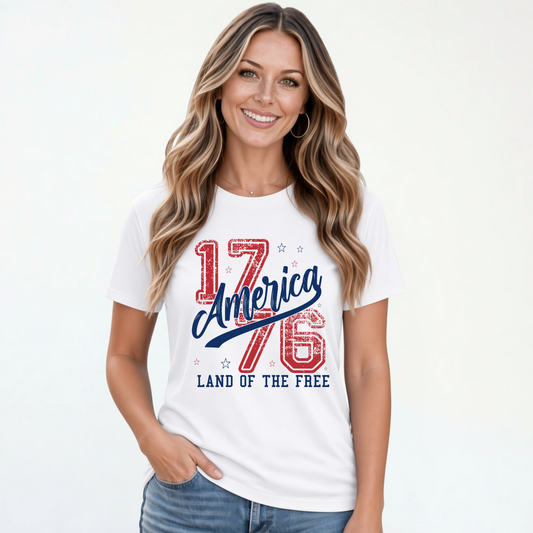 Smiling woman wearing a white T-shirt with a distressed red and blue America 1776 Land of the Free graphic