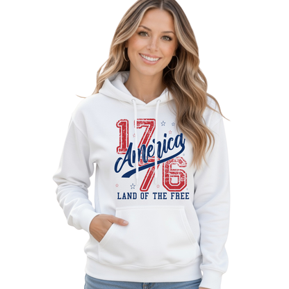 Smiling woman wearing a white pullover hoodie with a distressed red and blue America 1776 Land of the Free graphic