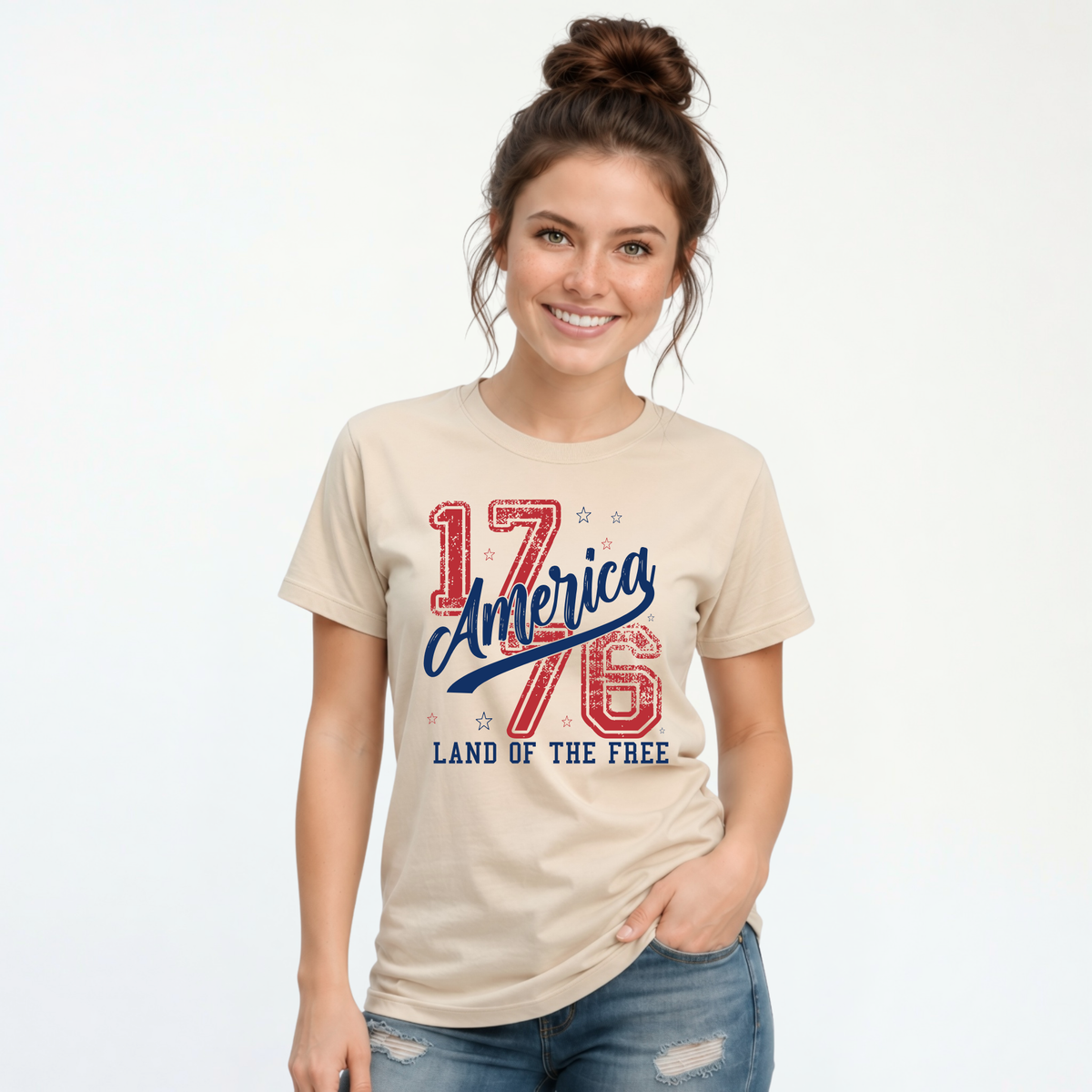 Woman wearing a sand T-shirt with a distressed red and blue America 1776 Land of the Free graphic