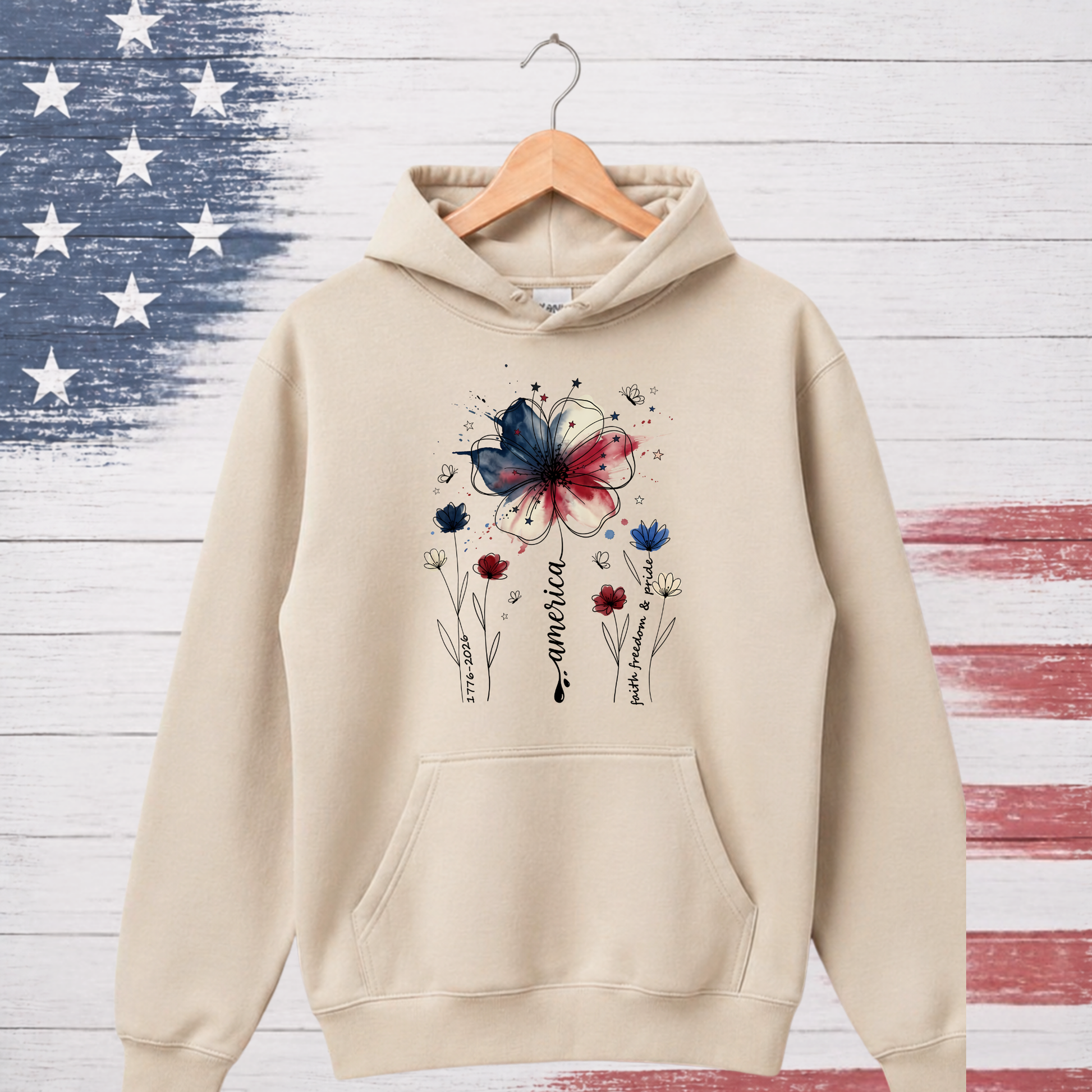 Beige hoodie with a butterfly and flower design on a wooden background with American flag pattern