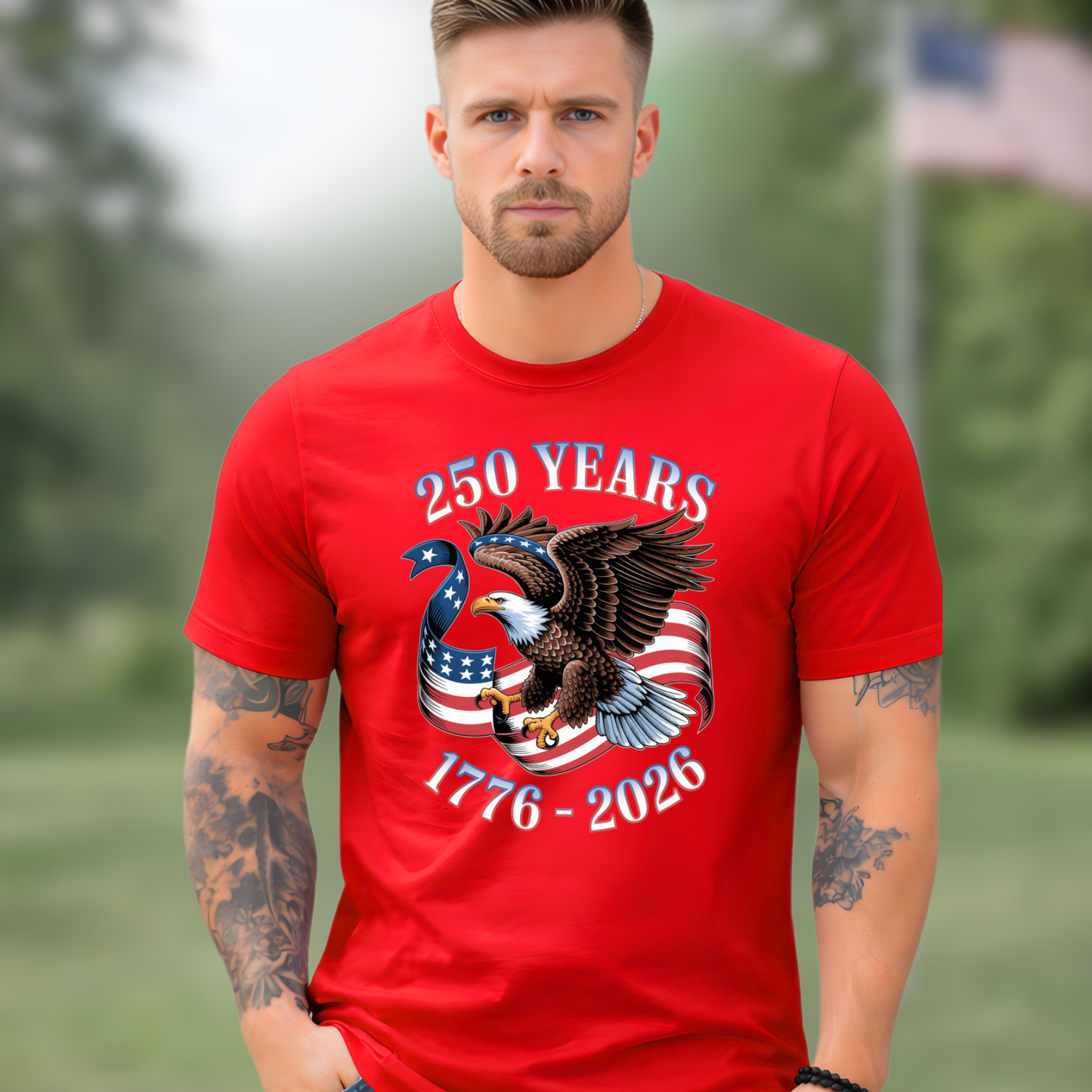 Man wearing a red America 250  t-shirt with an eagle and American flag design, standing outdoors.