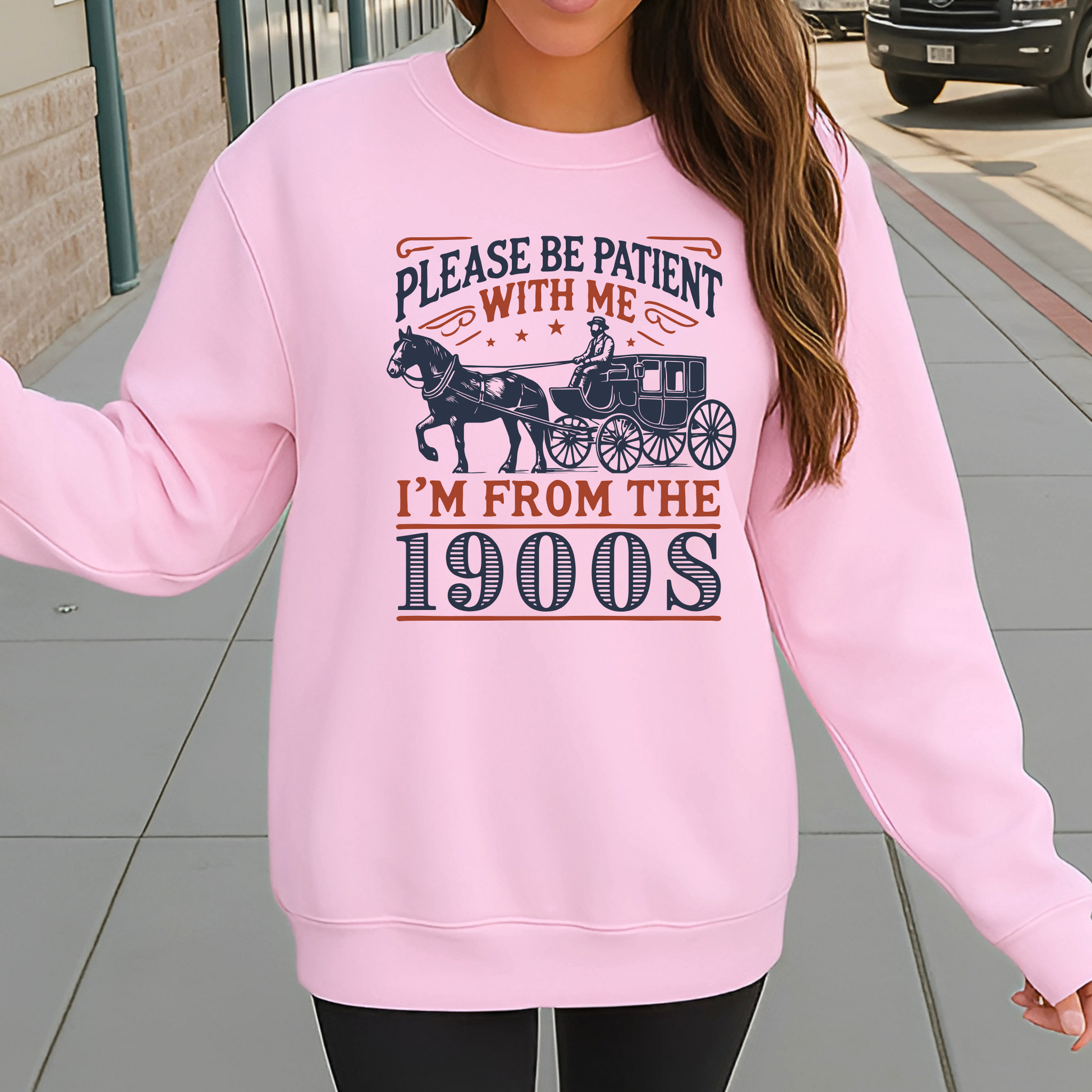 Model wearing light pink sweatshirt outdoors with Please Be Patient With Me I’m From the 1900s vintage design – cozy unisex crewneck sweater