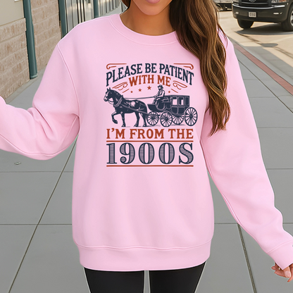 Model wearing light pink sweatshirt outdoors with Please Be Patient With Me I’m From the 1900s vintage design – cozy unisex crewneck sweater