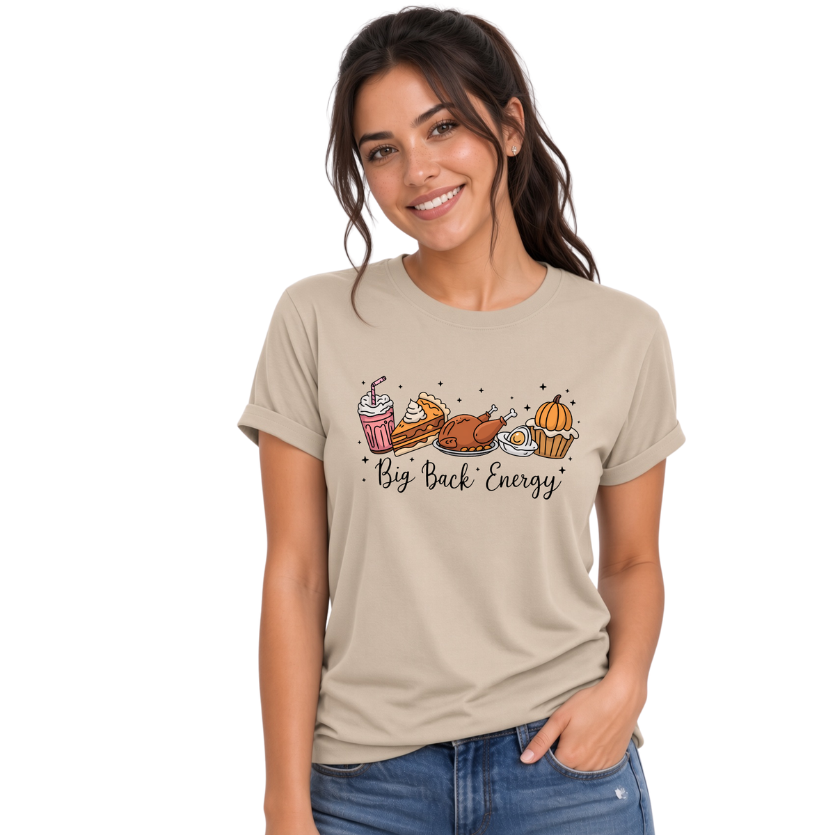 Woman in blue jeans models a sand T-shirt printed with the Big Back Energy Thanksgiving illustration on a white background.