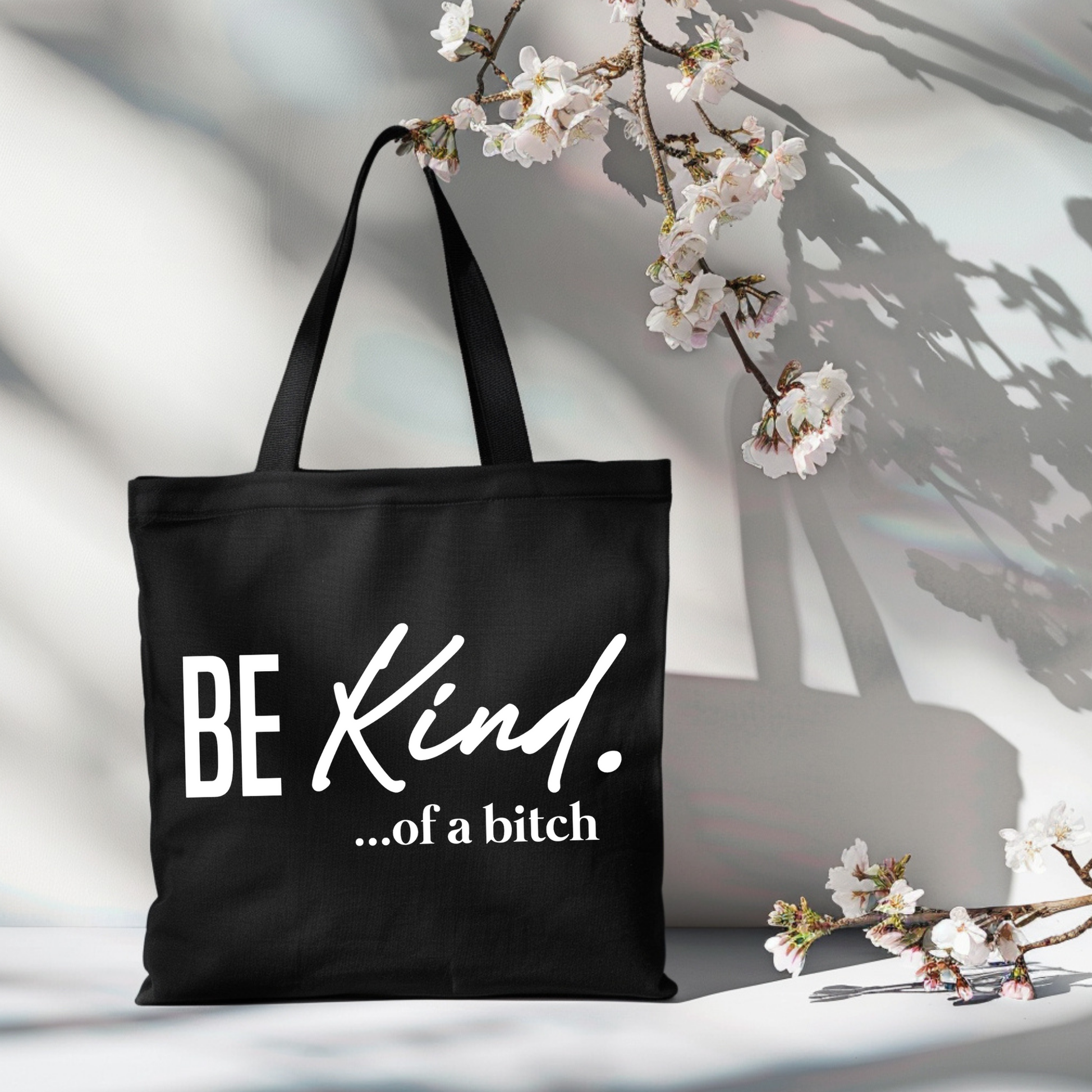 Black-handled tote angled on table with bold sarcastic quote