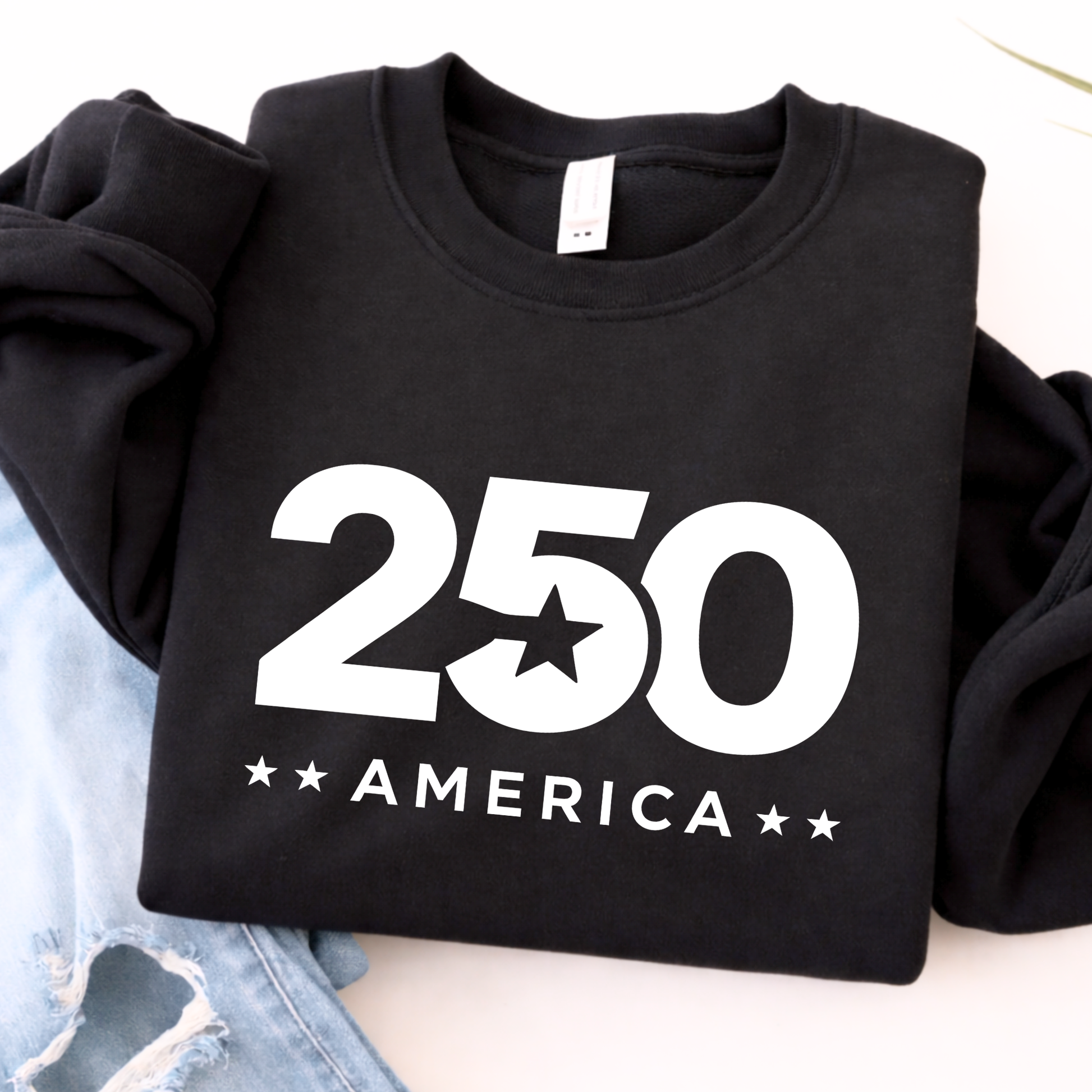 Black sweatshirt with '250 America' printed on it, laid flat on a light surface.