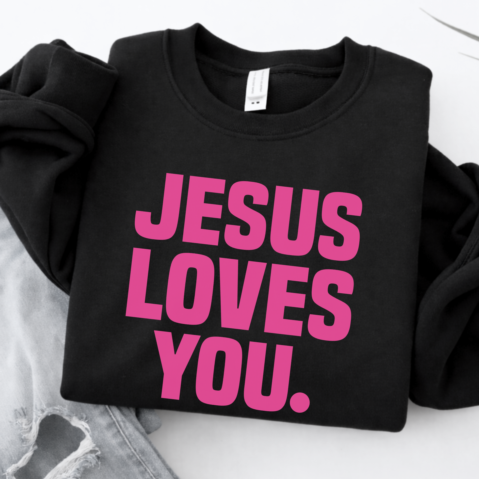 Black sweatshirt with 'Jesus Loves You' in pink text on a white background