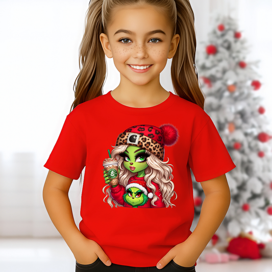 Youth red Christmas T-shirt with Boujee Green Girl holiday graphic, worn by a smiling girl in front of a Christmas tree. Cute kids holiday shirt for girls.
