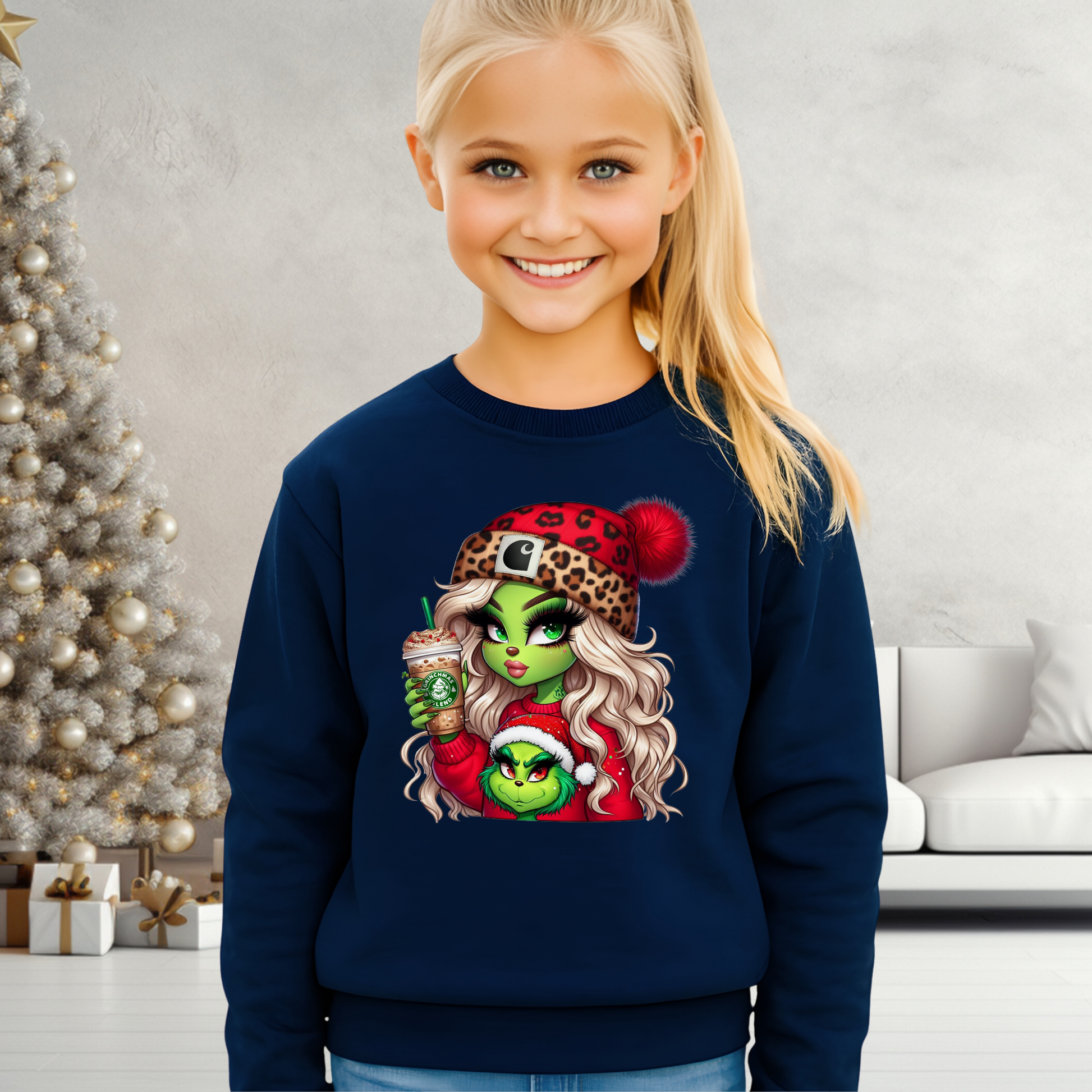 Child wearing a navy blue sweatshirt with a festive design, standing in a room decorated for Christmas.