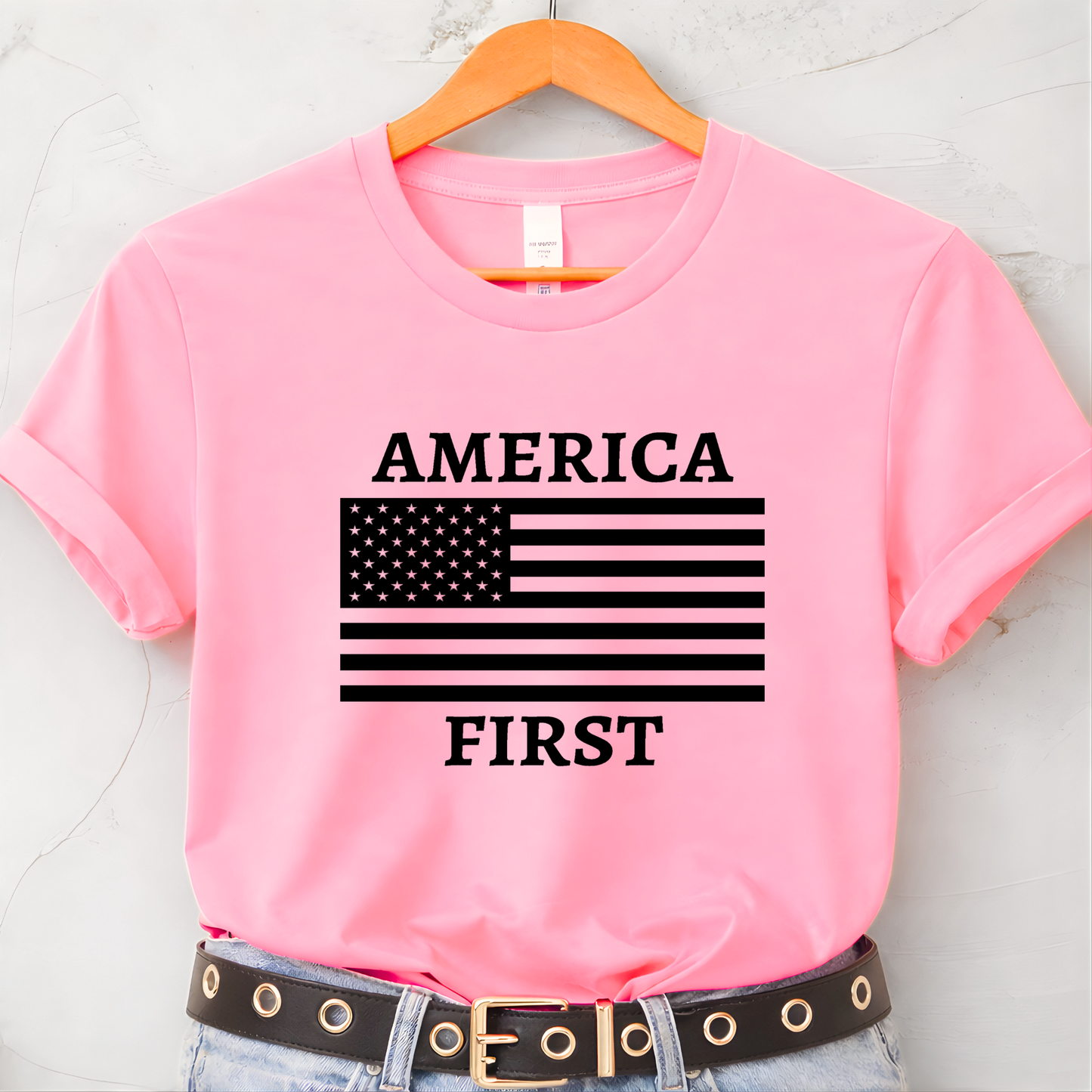 Bright pink America First patriotic women’s unisex t-shirt with black American flag design