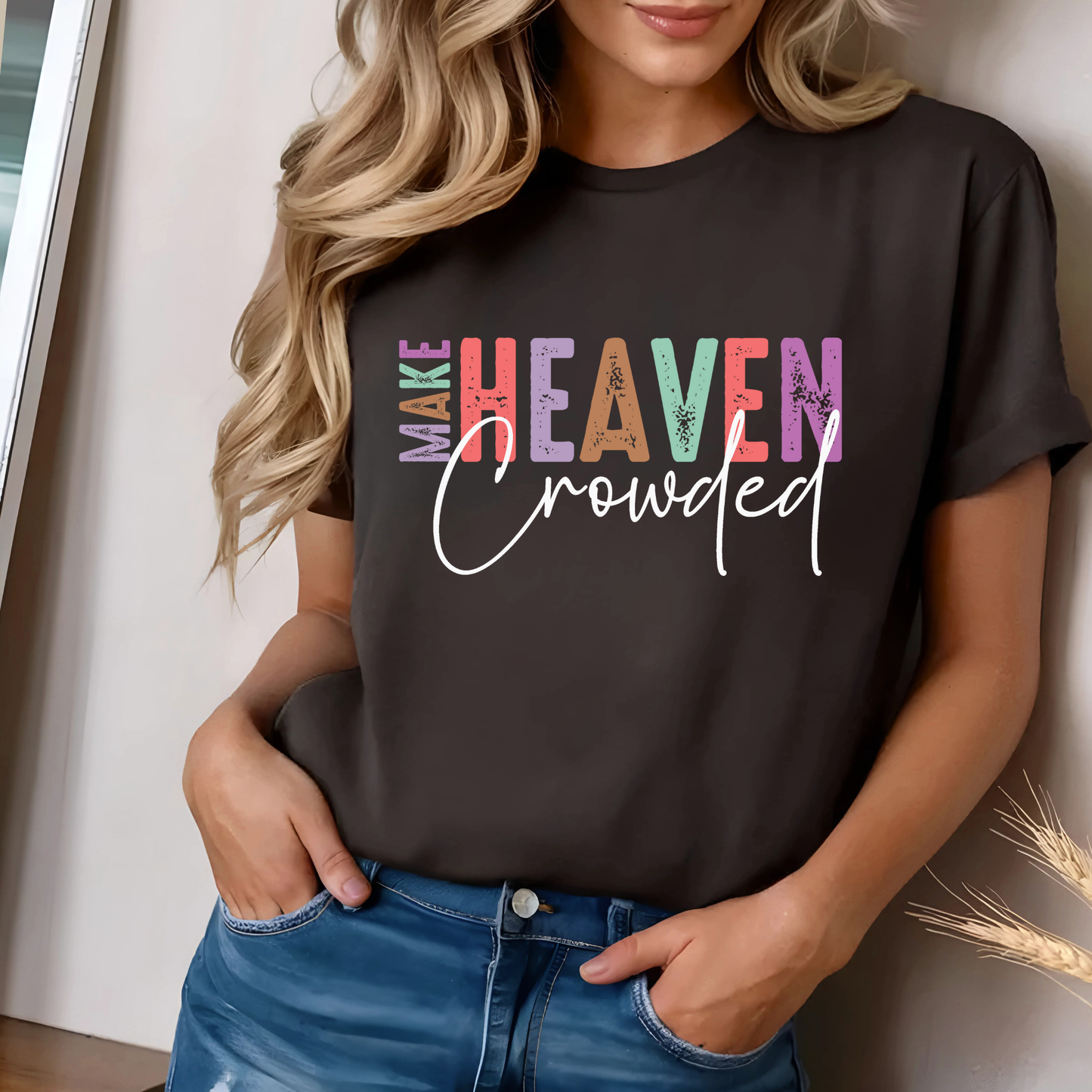 Woman in brown Make Heaven Crowded T-shirt smiling indoors with casual shorts