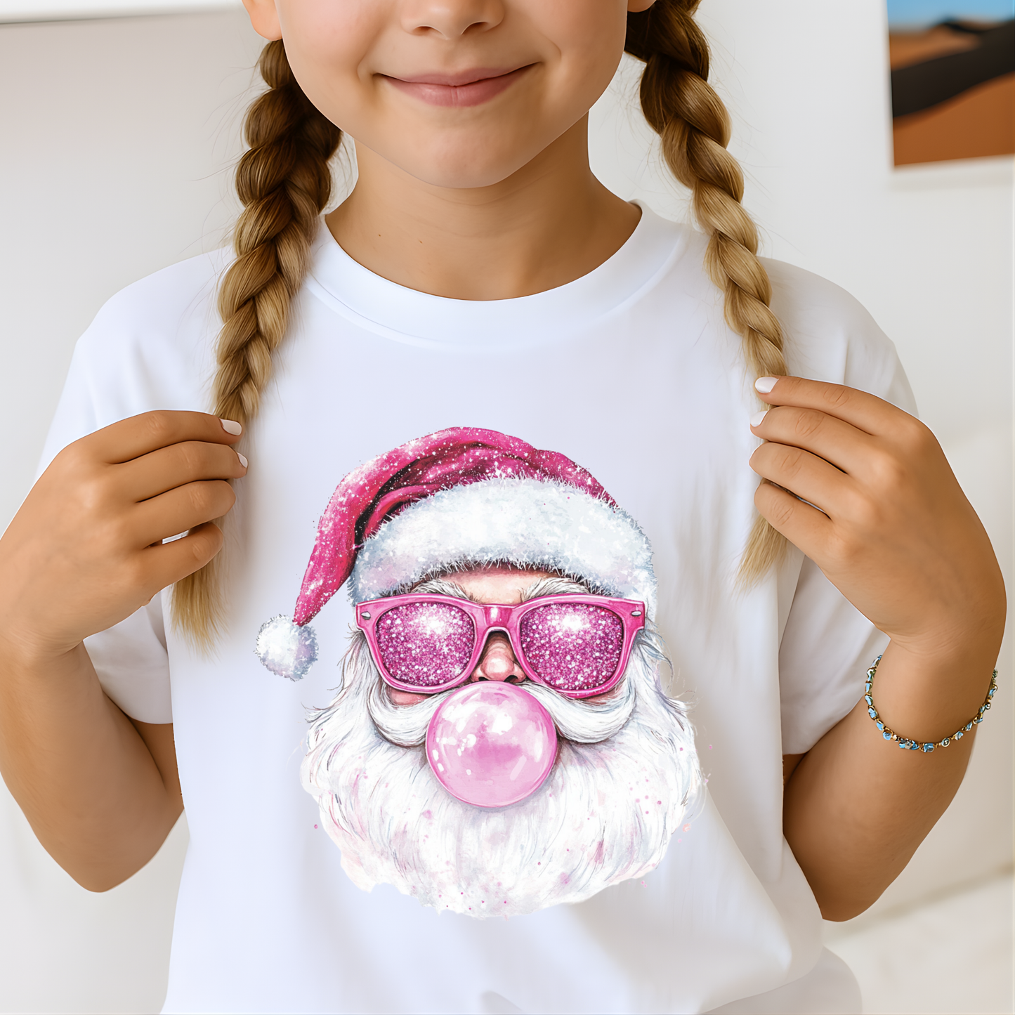 Child holding white T-shirt with pink bubblegum Santa design