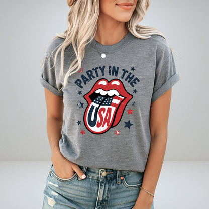 Stylish woman wearing a charcoal gray “Party in the USA” T-shirt with vintage-style patriotic lips design. Ideal for Independence Day, fireworks events, and relaxed summer Americana fashion.

