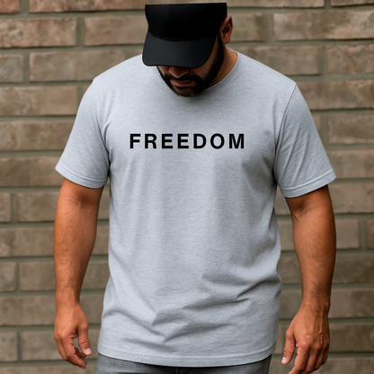 Man wearing a gray t-shirt with 'FREEDOM' printed on it against a brick wall.