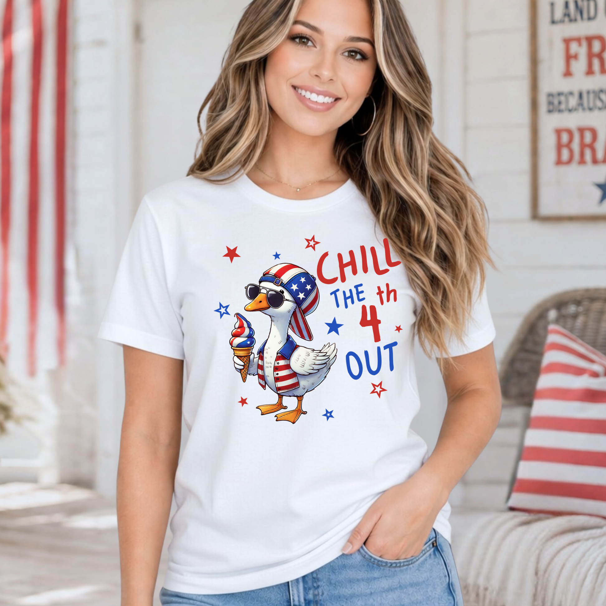Woman wearing a white t-shirt with a patriotic design, sitting in a room with a flag in the background.