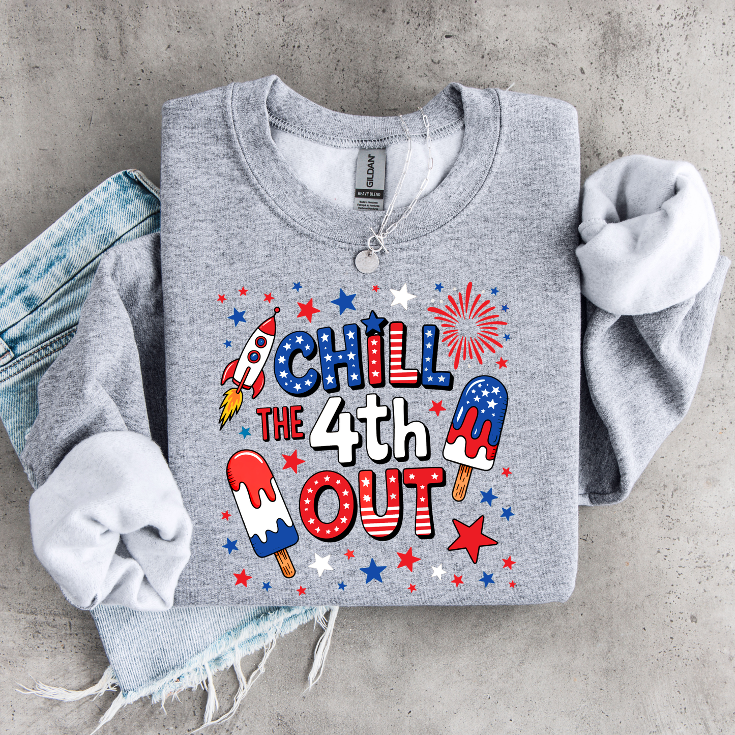 Gray sweatshirt with 4th of July-themed design on a concrete surface