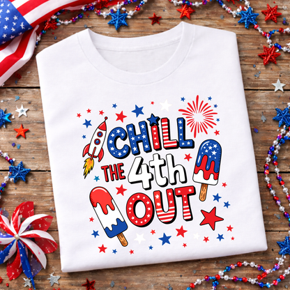 White t-shirt with 4th of July design on a wooden surface with festive decorations.